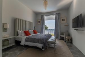 ein Schlafzimmer mit einem Bett mit roten Kissen und einem Fenster in der Unterkunft Lusa Beach Studios Under New Management And Newly Renovated in Lovina
