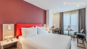 a hotel room with a large bed and a desk at Atlantis Home Suites Zona T in Bogotá