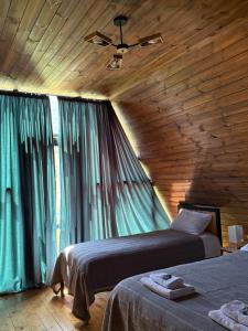 a bedroom with two beds and a wooden ceiling at Deka Achkhoti in Kazbegi