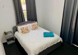 a small bed with a blue box on top of it at Miners' cottage in Broken Hill