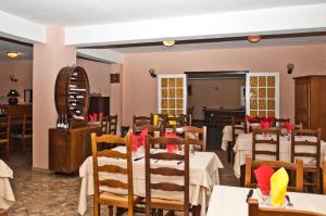 a restaurant with white tables and chairs and a mirror at Le FLORIDA in Zicavo