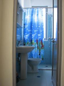a bathroom with a sink and a shower curtain at Aparthotel Vila Tufi in Velipojë +173 photos