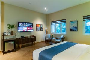 a bedroom with a large bed and a flat screen tv at Anise Luxe Home in Ho Chi Minh City