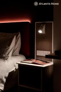 a room with a bed and a table with a book at Atlantis Home Suites Zona T in Bogotá