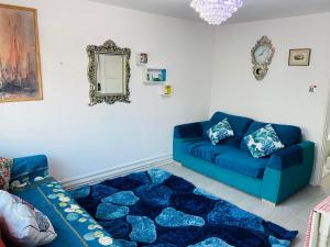 a living room with a blue couch and a rug at Cosy Home in Chatham in Chatham