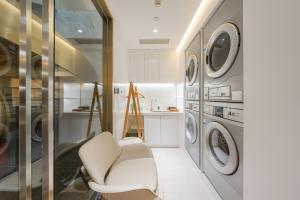 a laundry room with a chair and washing machines at Atour Hotel Beijing Asian Games Village National Convention Center in Beijing