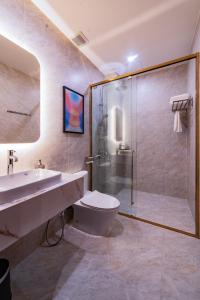 a bathroom with a shower and a toilet and a sink at Anise Luxe Home in Ho Chi Minh City +32 photos