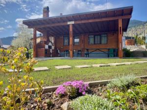a log cabin with a garden in front of it at Casa Ambra in Sadova