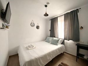a small bedroom with a white bed with a window at Casa Ambra in Sadova +24 photos