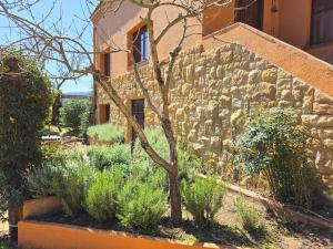 a stone wall with a tree in front of a building at Casa de campo en el Empordà in Cruïlles +25 photos