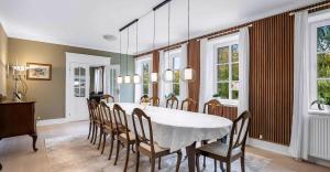 una sala da pranzo con tavolo e sedie bianchi di Spacious House With Room For Relaxation And Play a Brenderup