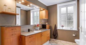 un bagno con lavandino e specchio di Spacious House With Room For Relaxation And Play a Brenderup Altre 30 foto