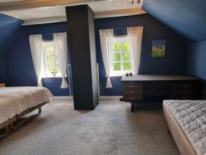 una camera blu con due letti e due finestre di Spacious House With Room For Relaxation And Play a Brenderup