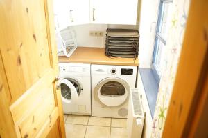a small laundry room with a washer and dryer at Landhaus 2 Stettinerhaff in Dargen