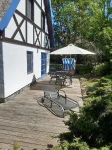 a patio with a table and chairs and an umbrella at Landhaus 2 Stettinerhaff in Dargen
