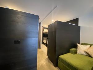 a bedroom with a green couch and a bed at Konayuki Apartment 4 in Falls Creek