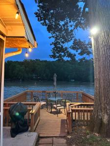 a wooden deck with a table and chairs on the water at Rivers Edge - On the River, Breathtaking views! in Front Royal