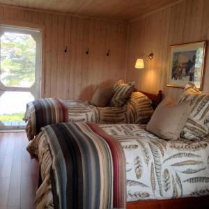a bedroom with two beds and a window at Pourvoirie La Corneille in Havre-Saint-Pierre