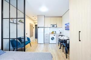 a room with a kitchen and a table with chairs at 1 room apartment CITY PLUS 4 in Almaty