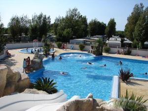 a large swimming pool with people swimming in it at Camping Phare Ouest in Saint-Denis-dʼOléron