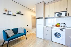 a kitchen with a washing machine and a blue chair at 1 room apartment CITY PLUS 4 in Almaty