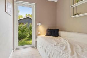 a bedroom with a bed and a large window at New House Near Asserbo Plantation And Arresø in Frederiksværk