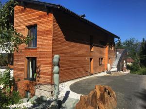 a wooden house with a rock in front of it at Appartement Györi. in Millstatt