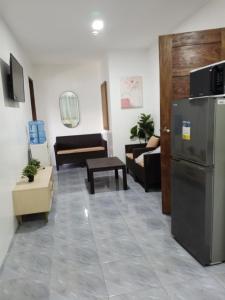 uma sala de estar com um frigorífico e um sofá em Baguio De Bisita em Baguio mais 3 fotografias