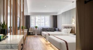 une chambre d'hôtel avec deux lits et un canapé dans l'établissement GYA Hotel Heze Zhonghua Road Jiahe Plaza, à Heze 226 autres photos