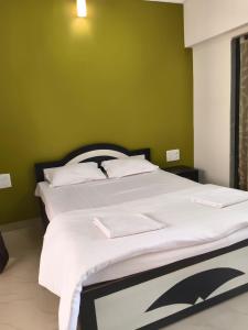 a bedroom with a large bed with green walls at Panchgani Palace in Panchgani