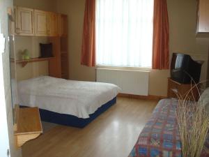 sypialnia z łóżkiem i telewizorem w obiekcie Kornél Apartman w Siófoku