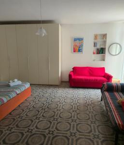 a living room with a couch and a red couch at Happy House Corricella in Procida