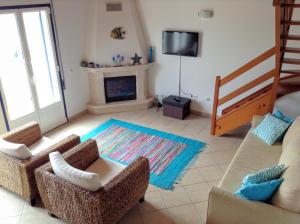 a living room with two chairs and a fireplace at Casa Trinta - Praia da Arrifana in Praia da Arrifana