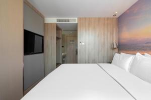 a bedroom with a large bed and a flat screen tv at 青年阳光酒店有限公司 in Xiamen