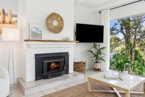 a living room with a fireplace and a tv at Sunset Palms in Palm Beach +8 photos