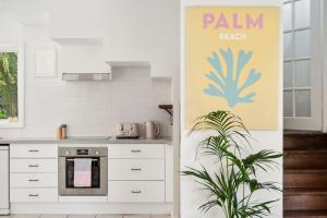 a kitchen with white cabinets and a potted plant at Sunset Palms in Palm Beach