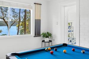 a living room with a pool table and a window at Sunset Palms in Palm Beach