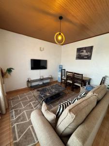 a living room with a couch and a flat screen tv at Eldoret Hideout Cozy 1-Bed Along Kisumu Road Near Tamasha in Eldoret