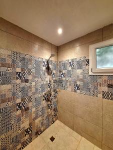 ein gefliestes Bad mit einer Dusche und einem Fenster in der Unterkunft Orientalna Willa in Hurghada