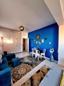 ein Wohnzimmer mit blauen Wänden sowie einem Tisch und Stühlen in der Unterkunft Orientalna Willa in Hurghada
