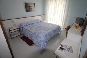 a bedroom with a bed with a blue comforter at Hotel Liliana Andora citr 9006-0004 in Marina di Andora +44 photos