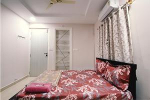a bedroom with a red bed and a window at The Sunbird in Kondapur
