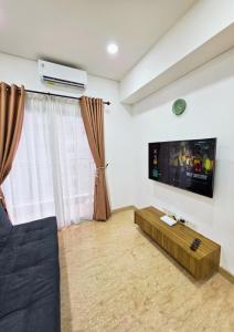 a living room with a flat screen tv on the wall at Apartment - 2 bedroom, 3 beds in Medan
