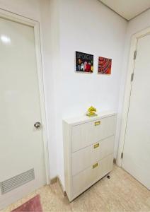 a white bedroom with a dresser and a door at Apartment - 2 bedroom, 3 beds in Medan
