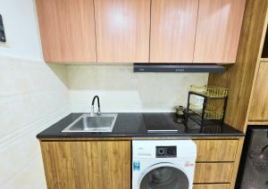 a kitchen with a sink and a washing machine at Apartment - 2 bedroom, 3 beds in Medan