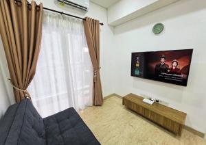 a living room with a flat screen tv on the wall at Apartment - 2 bedroom, 3 beds in Medan +4 photos