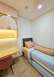 a small bedroom with a bed and a desk at Apartment - 2 bedroom, 3 beds in Medan