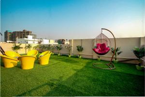 a balcony with chairs and a hammock on the grass at The Sunbird in Kondapur