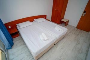 1 dormitorio con 1 cama con sábanas blancas y toallas en Next to Harmanite Beach - 1 BD Flat with Own Parking spot by Flat Mаnager, en Sozopol