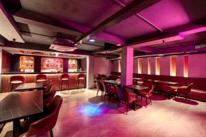 a restaurant with tables and chairs and purple lighting at Sathyam Oasis in Tiruchirappalli